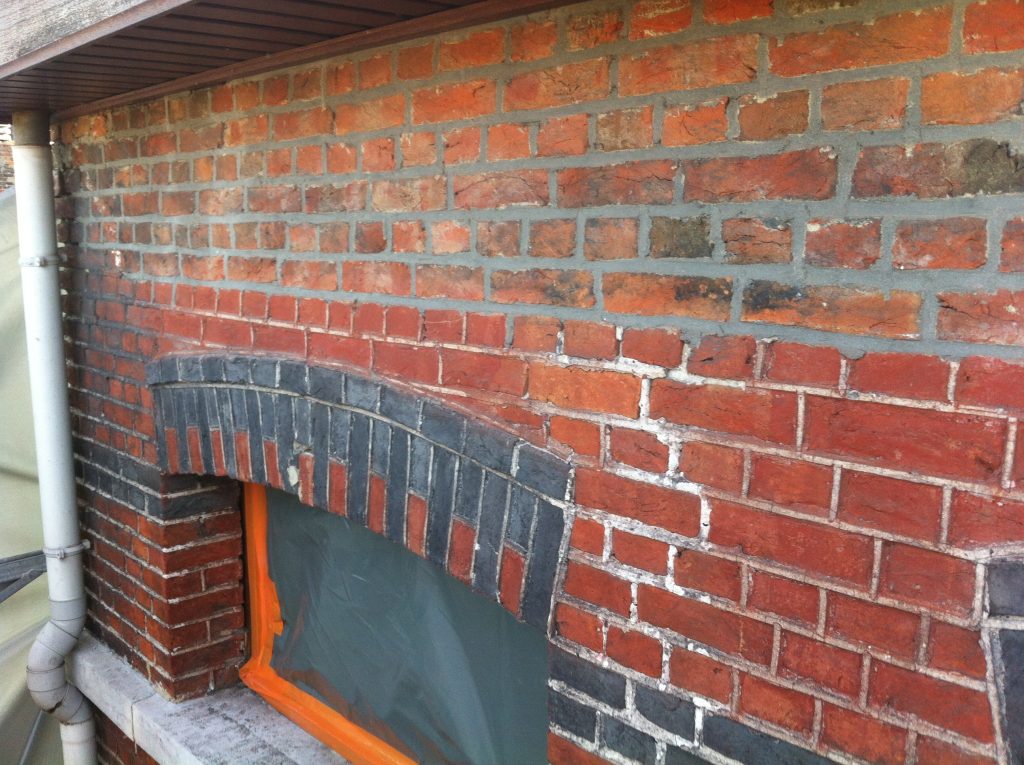 "Detail of a brick wall showing two distinct mortar phases. The upper section has been repointed with hard cement mortar - a detrimental repair that has since been removed! The lower section retains the original lime mortar joints, over 130 years old, with typical "geknipte" joints showing natural erosion and aging."