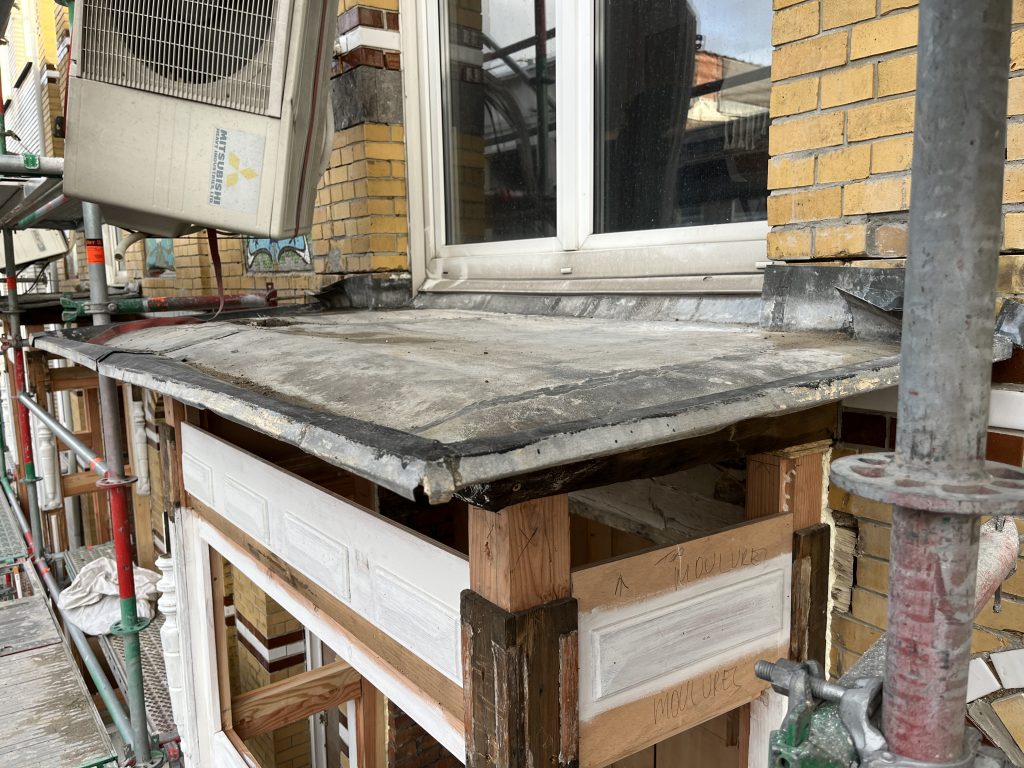 "Existing old weathered zinc sheeting, still -covering the restored bay window framework, serving as a protective weather screen during contstruction. To be replaced with new zinc sheeting afterward!"
